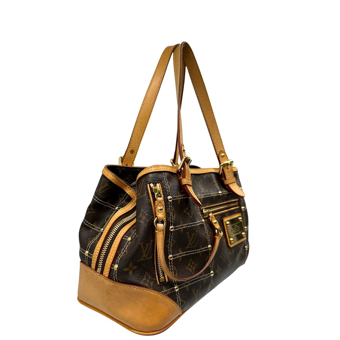 Laterale sinistro di una borsa Louis Vuitton in canvas marrone monogram con cuciture decorative e finiture in vacchetta naturale. Parti metalliche dorate; munita di doppi manici, indossabile a spalla.