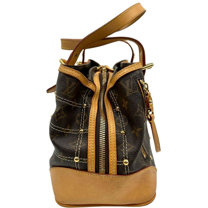 Laterale di una borsa Louis Vuitton in canvas marrone monogram con cuciture decorative e finiture in vacchetta naturale. Parti metalliche dorate; munita di doppi manici, indossabile a spalla.