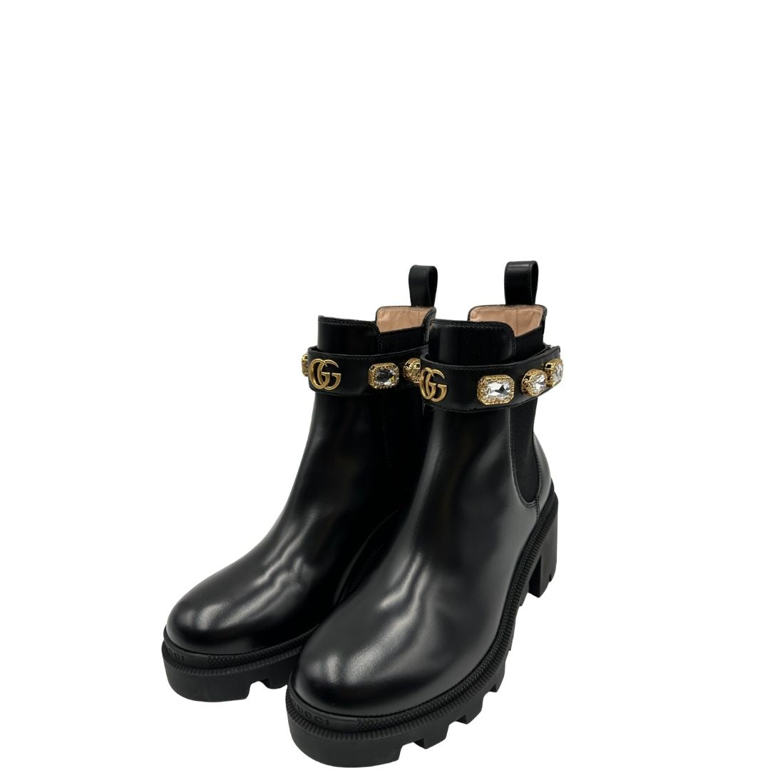 Stivaletti Gucci in pelle nera con inserti metallici dorati, zirconi e logo GG in metallo