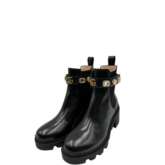Stivaletti Gucci in pelle nera con inserti metallici dorati, zirconi e logo GG in metallo
