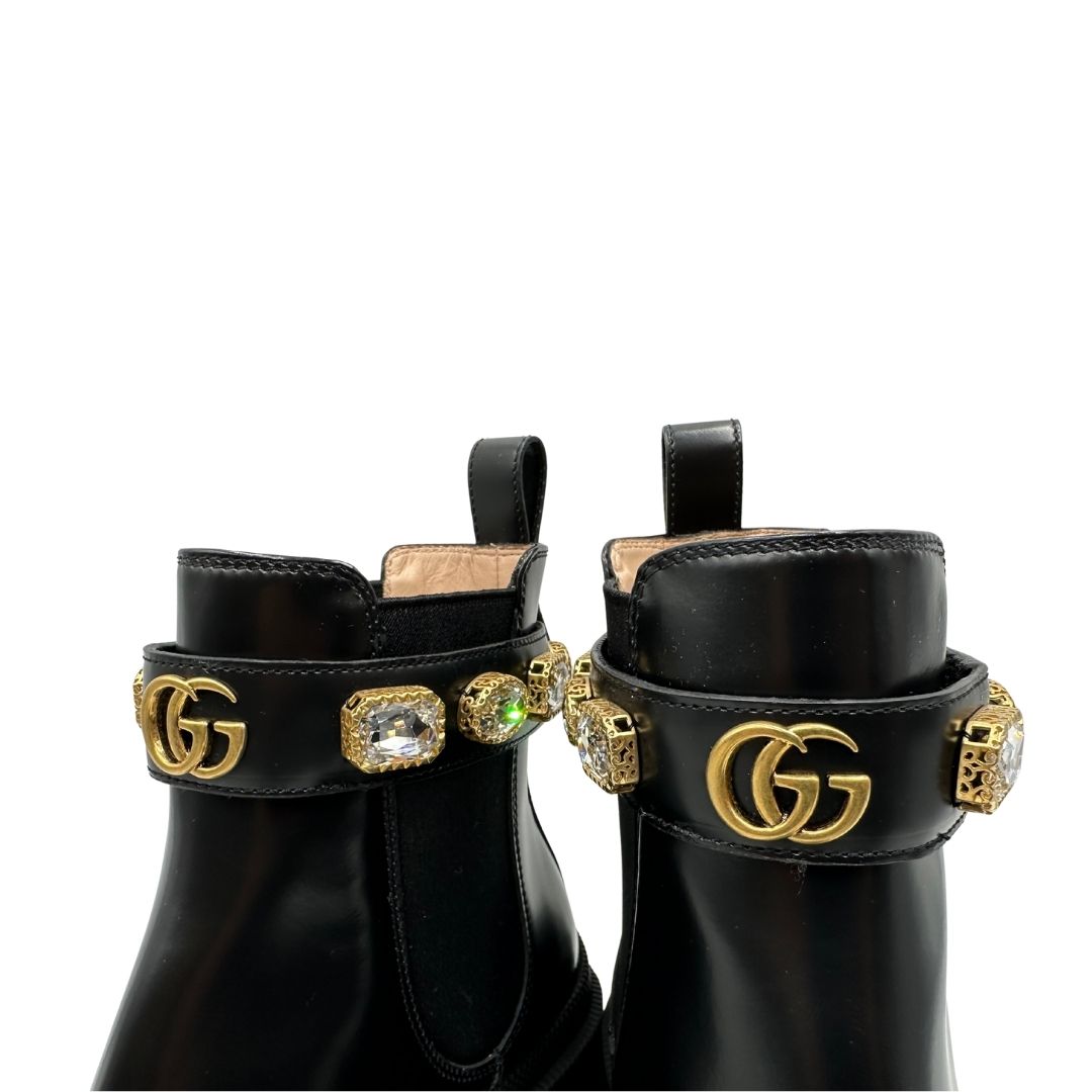Stivaletti Gucci in pelle nera con inserti metallici dorati, zirconi e logo GG in metallo