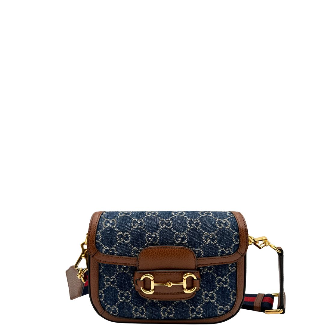 front Borsa Gucci in tessuto effetto denim con trama GG , finiture in pelle marroni e parti metalliche dorate; munita di una tracolla Web in tessuto blu e rossa e una tracolla in pelle, entrambe amovibili e regolabili. Completa di dustbag, di lusso, originale, eccellenti condizioni. 