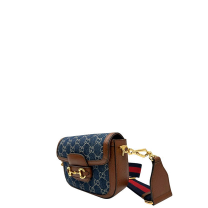 lato Borsa Gucci in tessuto effetto denim con trama GG , finiture in pelle marroni e parti metalliche dorate; munita di una tracolla Web in tessuto blu e rossa e una tracolla in pelle, entrambe amovibili e regolabili. Completa di dustbag, di lusso, originale, eccellenti condizioni. 