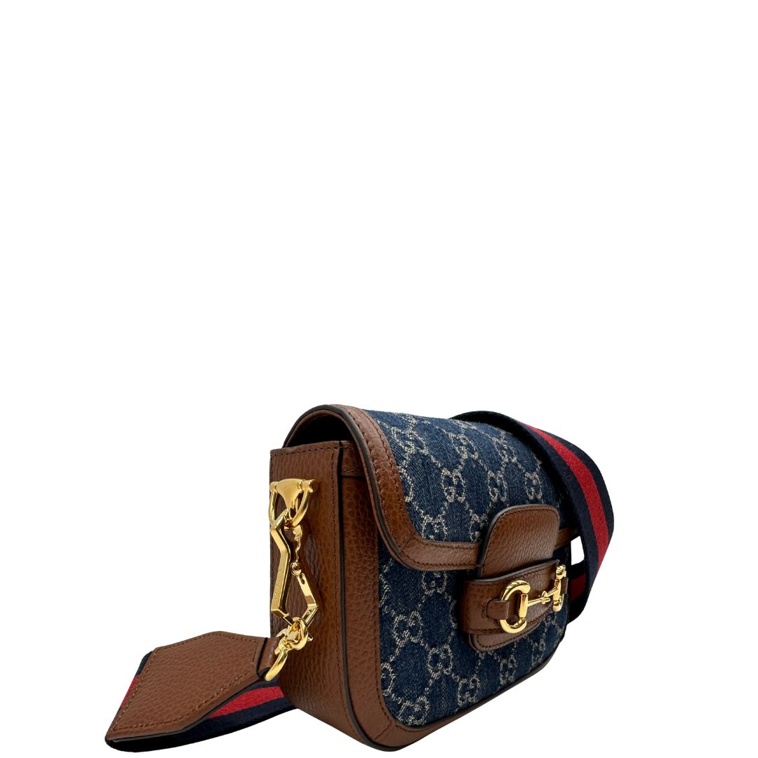 lato Borsa Gucci in tessuto effetto denim con trama GG , finiture in pelle marroni e parti metalliche dorate; munita di una tracolla Web in tessuto blu e rossa e una tracolla in pelle, entrambe amovibili e regolabili. Completa di dustbag, di lusso, originale, eccellenti condizioni. 