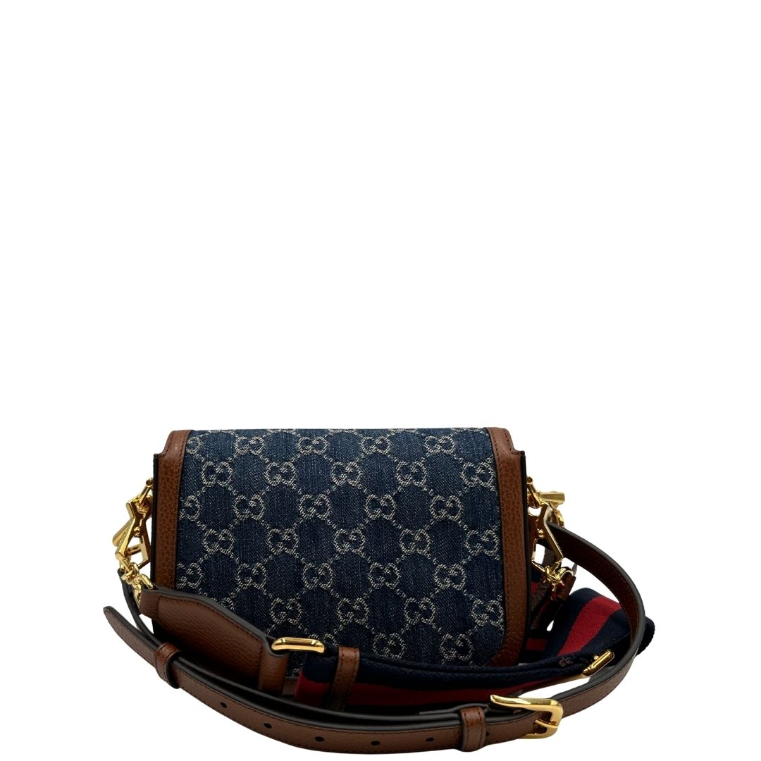 retro Borsa Gucci in tessuto effetto denim con trama GG , finiture in pelle marroni e parti metalliche dorate; munita di una tracolla Web in tessuto blu e rossa e una tracolla in pelle, entrambe amovibili e regolabili. Completa di dustbag, di lusso, originale, eccellenti condizioni. 