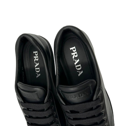  Sneakers Prada in pelle nera con lacci tono su tono. Complete di scatola, di lusso, originali, ottime condizioni.