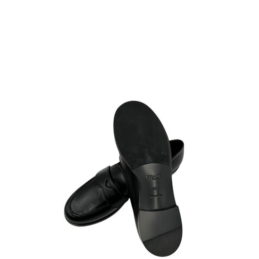 Mocassini Prada in pelle nera con dettaglio triangolare che richiama l'iconico logo. Completi di scatola, di lusso, originale, ottime condizioni.