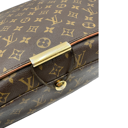 Chiusura di una Cartella Louis Vuitton in canvas marrone monogram con finiture in vacchetta naturale e parti metalliche dorate. Munita di una tracolla in tessuto regolabile. Originale, usata, di lusso, in ottime condizioni