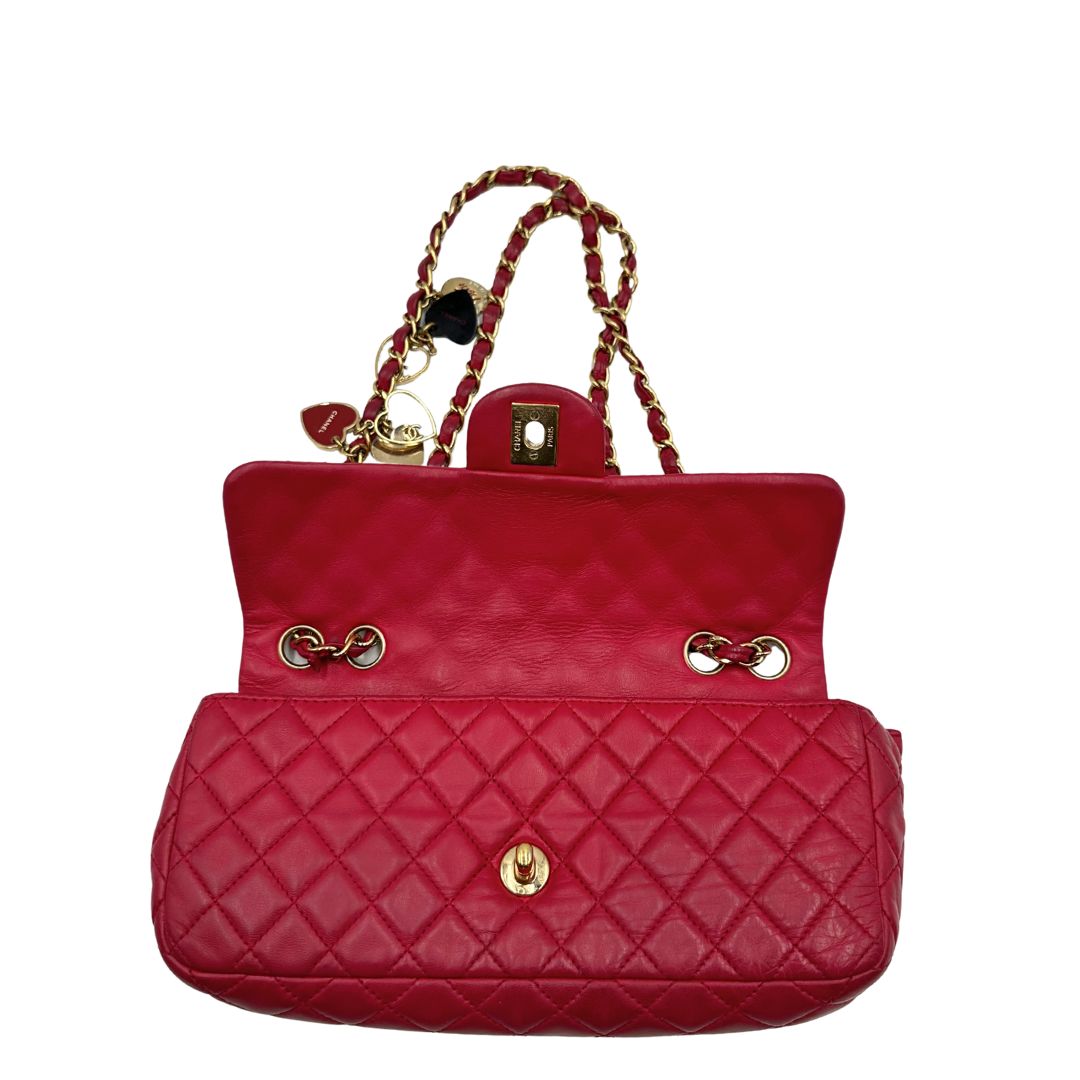 Interno di una Borsa Chanel Gabrielle in pelle matelassé color fucsia con parti metalliche dorate; impreziosita da charm con cuoricini sulla tracolla intrecciata in catena e pelle. Completa di scatola e card di autenticità. Originale, usata, di lusso in ottime condizioni