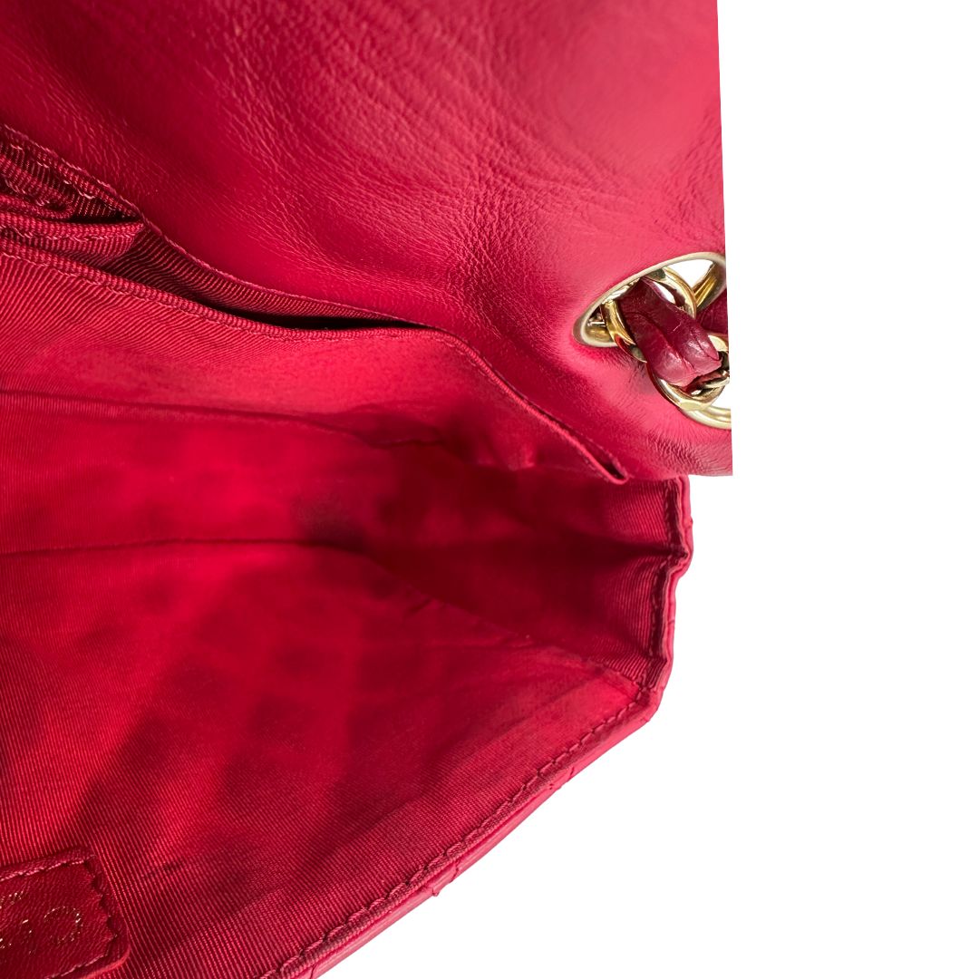 Interno di una Borsa Chanel Gabrielle in pelle matelassé color fucsia con parti metalliche dorate; impreziosita da charm con cuoricini sulla tracolla intrecciata in catena e pelle. Completa di scatola e card di autenticità. Originale, usata, di lusso in ottime condizion