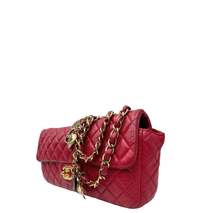 Lato sinistro di una Borsa Chanel Gabrielle in pelle matelassé color fucsia con parti metalliche dorate; impreziosita da charm con cuoricini sulla tracolla intrecciata in catena e pelle. Completa di scatola e card di autenticità. Originale, usata, di lusso in ottime condizioni