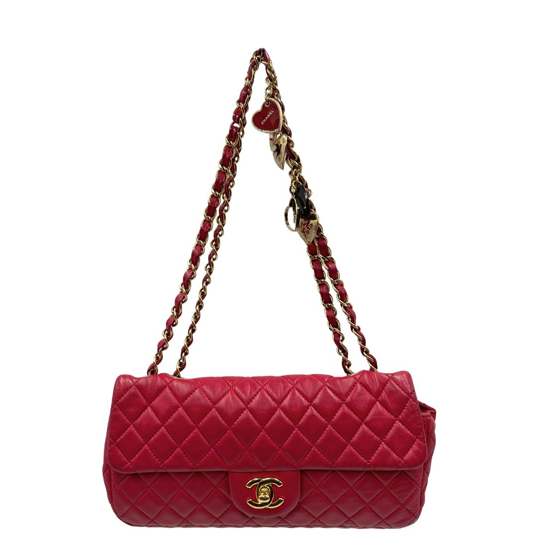 Front di una Borsa Chanel Gabrielle in pelle matelassé color fucsia con parti metalliche dorate; impreziosita da charm con cuoricini sulla tracolla intrecciata in catena e pelle. Completa di scatola e card di autenticità. Originale, usata, di lusso in ottime condizioni