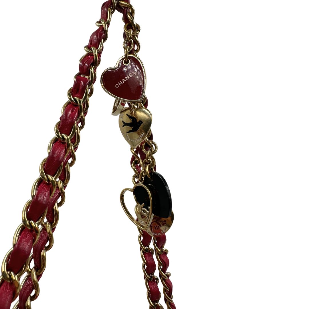 Tracolla di una Borsa Chanel Gabrielle in pelle matelassé color fucsia con parti metalliche dorate; impreziosita da charm con cuoricini sulla tracolla intrecciata in catena e pelle. Completa di scatola e card di autenticità. Originale, usata, di lusso in ottime condizioni