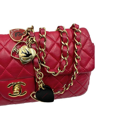 Tracolla di una Borsa Chanel Gabrielle in pelle matelassé color fucsia con parti metalliche dorate; impreziosita da charm con cuoricini sulla tracolla intrecciata in catena e pelle. Completa di scatola e card di autenticità. Originale, usata, di lusso in ottime condizioni
