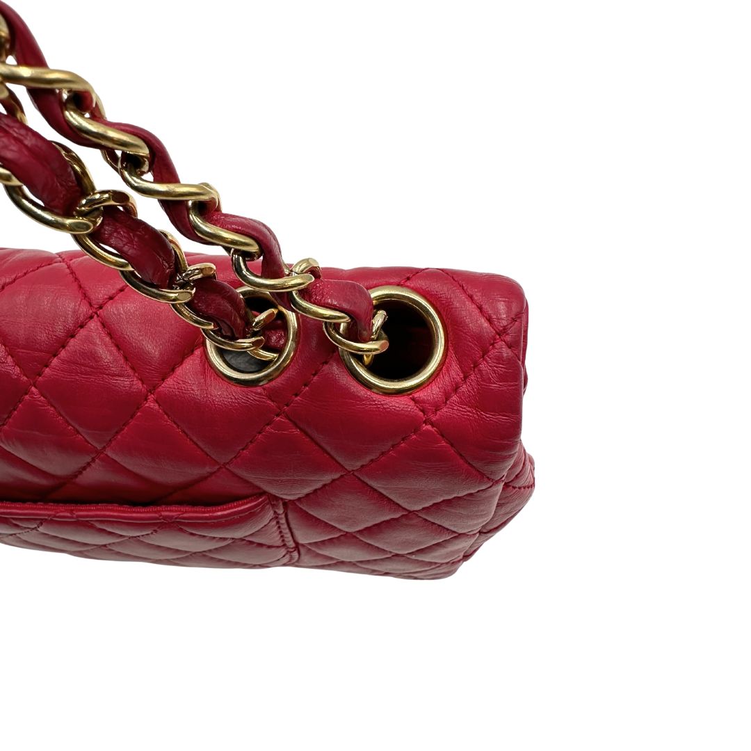 una Borsa Chanel Gabrielle in pelle matelassé color fucsia con parti metalliche dorate; impreziosita da charm con cuoricini sulla tracolla intrecciata in catena e pelle. Completa di scatola e card di autenticità. Originale, usata, di lusso in ottime condizioni