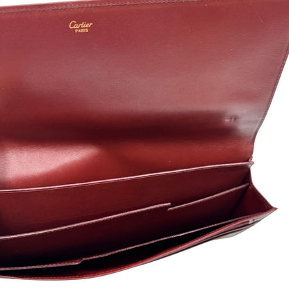 interni  Clutch Les Must de Cartier in pelle bordeaux con parti metalliche dorate. Munito di scatola, di lusso, originale.
