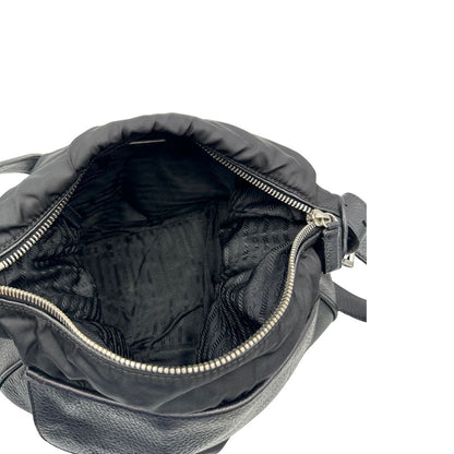 Interno di una Borsa Prada in nylon nero con parti metalliche argentate e dettagli in pelle tono su tono. Munita di una tracolla regolabile con fibbie, rifinita con logo triangolare sul lato destro. Originale, usata, di lusso, in condizioni buone.