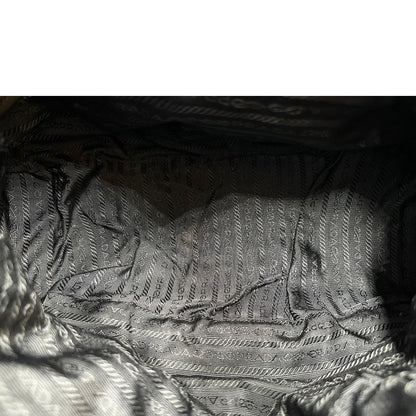 Interno di una Borsa Prada in nylon nero con parti metalliche argentate e dettagli in pelle tono su tono. Munita di una tracolla regolabile con fibbie, rifinita con logo triangolare sul lato destro. Originale, usata, di lusso, in condizioni buone.