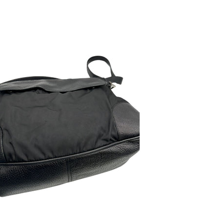 Borsa Prada in nylon nero con parti metalliche argentate e dettagli in pelle tono su tono. Munita di una tracolla regolabile con fibbie, rifinita con logo triangolare sul lato destro. Originale, usata, di lusso, in condizioni buone.
