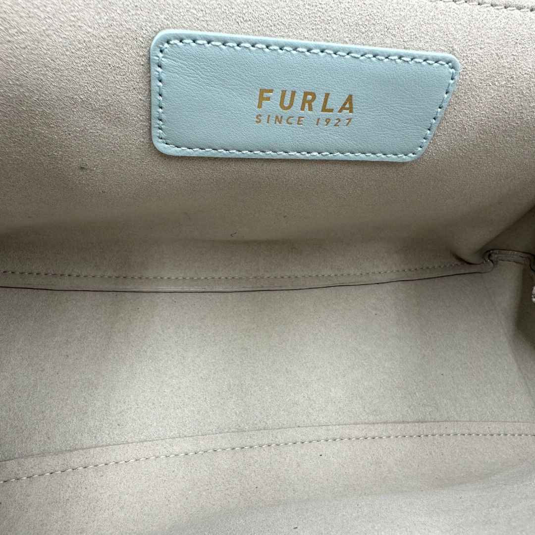 interno Borsa Furla in pelle celeste con parti metalliche dorate; munita di un manico in catena e una tracolla regolabile. Completa di dustbag, di lusso, usata. 