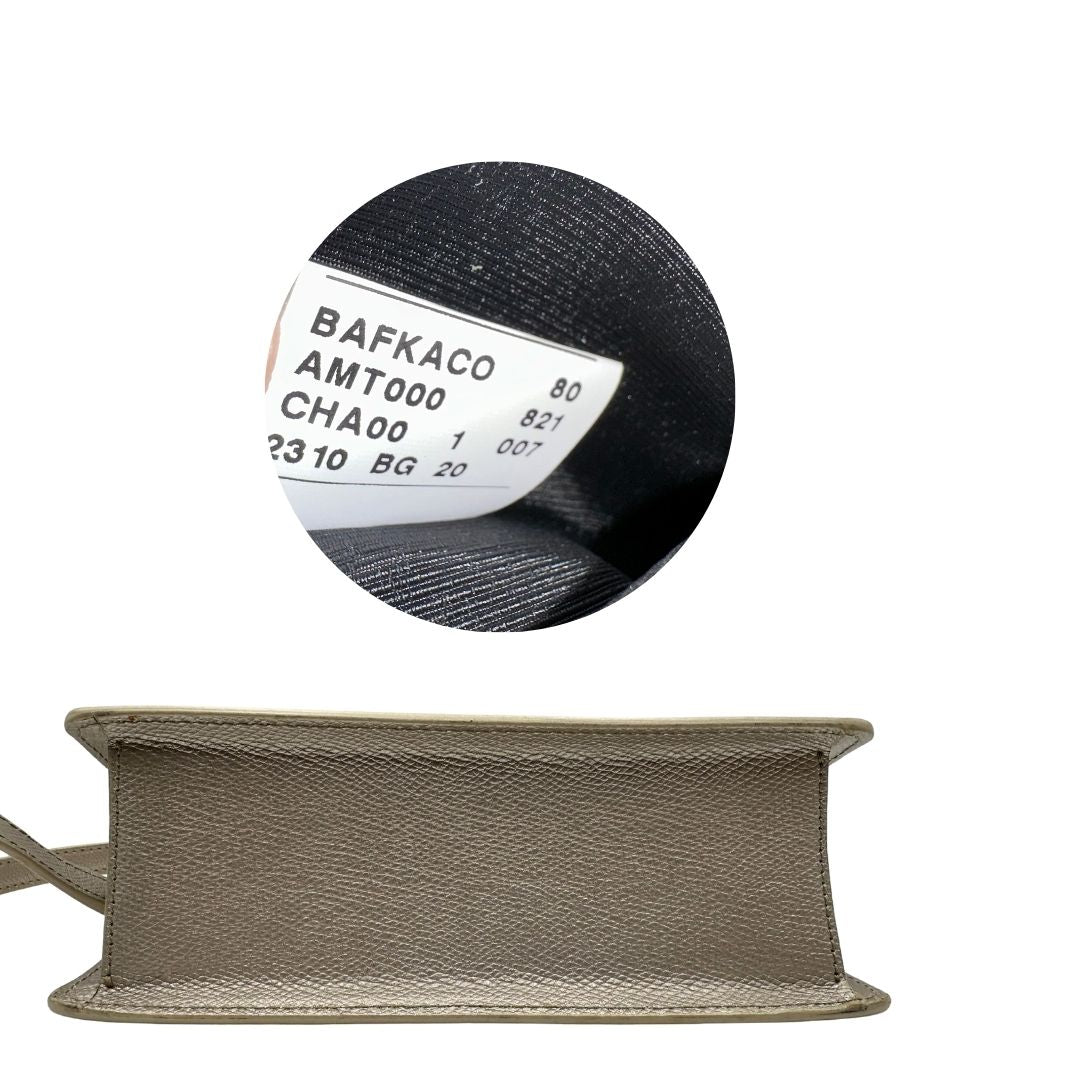 Base di una Pochette Furla in pelle martellata color champagne con parti metalliche dorate, munita di una tracolla in catena scorrevole con spallaccio in pelle. Completa di dustbag. Originale, usata, di lusso, in ottime condizioni