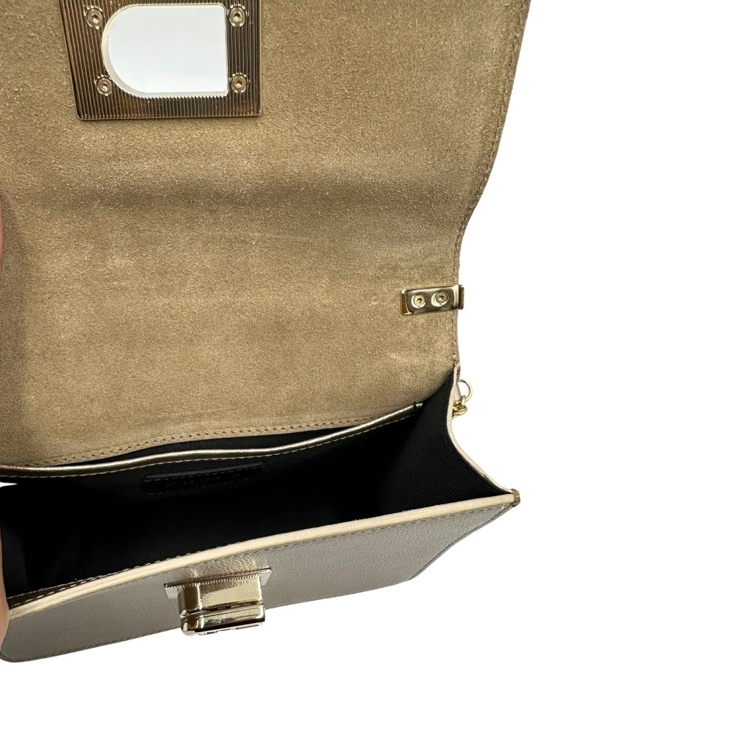Interno di una Pochette Furla in pelle martellata color champagne con parti metalliche dorate, munita di una tracolla in catena scorrevole con spallaccio in pelle. Completa di dustbag. Originale, usata, di lusso, in ottime condizioni