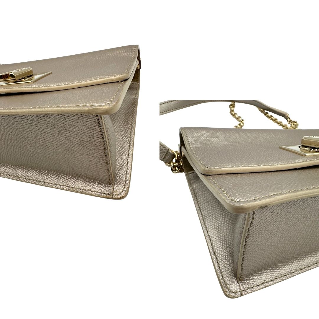 Angoli di una Pochette Furla in pelle martellata color champagne con parti metalliche dorate, munita di una tracolla in catena scorrevole con spallaccio in pelle. Completa di dustbag. Originale, usata, di lusso, in ottime condizioni
