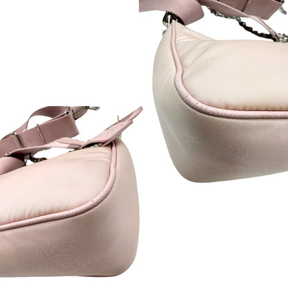 angoli Borsa Prada in nylon rosa con parti metalliche argentate e finiture in pelle tono su tono; munita di un mini pouch amovibile, un accessorio portachiavi, manico in catena e una tracolla in tessuto amovibile e regolabile, di lusso, originale, ottime condizioni. 