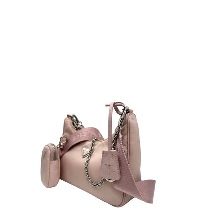 lato Borsa Prada in nylon rosa con parti metalliche argentate e finiture in pelle tono su tono; munita di un mini pouch amovibile, un accessorio portachiavi, manico in catena e una tracolla in tessuto amovibile e regolabile, di lusso, originale, ottime condizioni. 