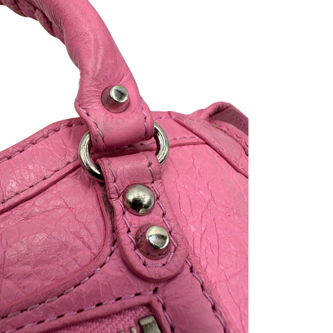 Borsa Neo Cagole Balenciaga City in pelle crinkled rosa bubblegum. Dotata di doppi manici con dettaglio intreccio e tracolla regolabile e amovibile, completa del classico specchietto. Rifinita con borchie in metallo argentato. Originale, usata, di lusso, in ottime condizioni