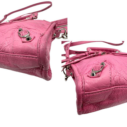 Angoli di una Borsa Neo Cagole Balenciaga City in pelle crinkled rosa bubblegum. Dotata di doppi manici con dettaglio intreccio e tracolla regolabile e amovibile, completa del classico specchietto. Rifinita con borchie in metallo argentato. Originale, usata, di lusso, in ottime condizioni