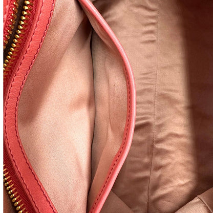 interno Borsa Miu Miu in pelle color rosa corallo con parti metalliche dorate; munita di doppi manici stondati e una tracolla amovibile. Completa di dustbag, di lusso, originale, ottime condizioni. 