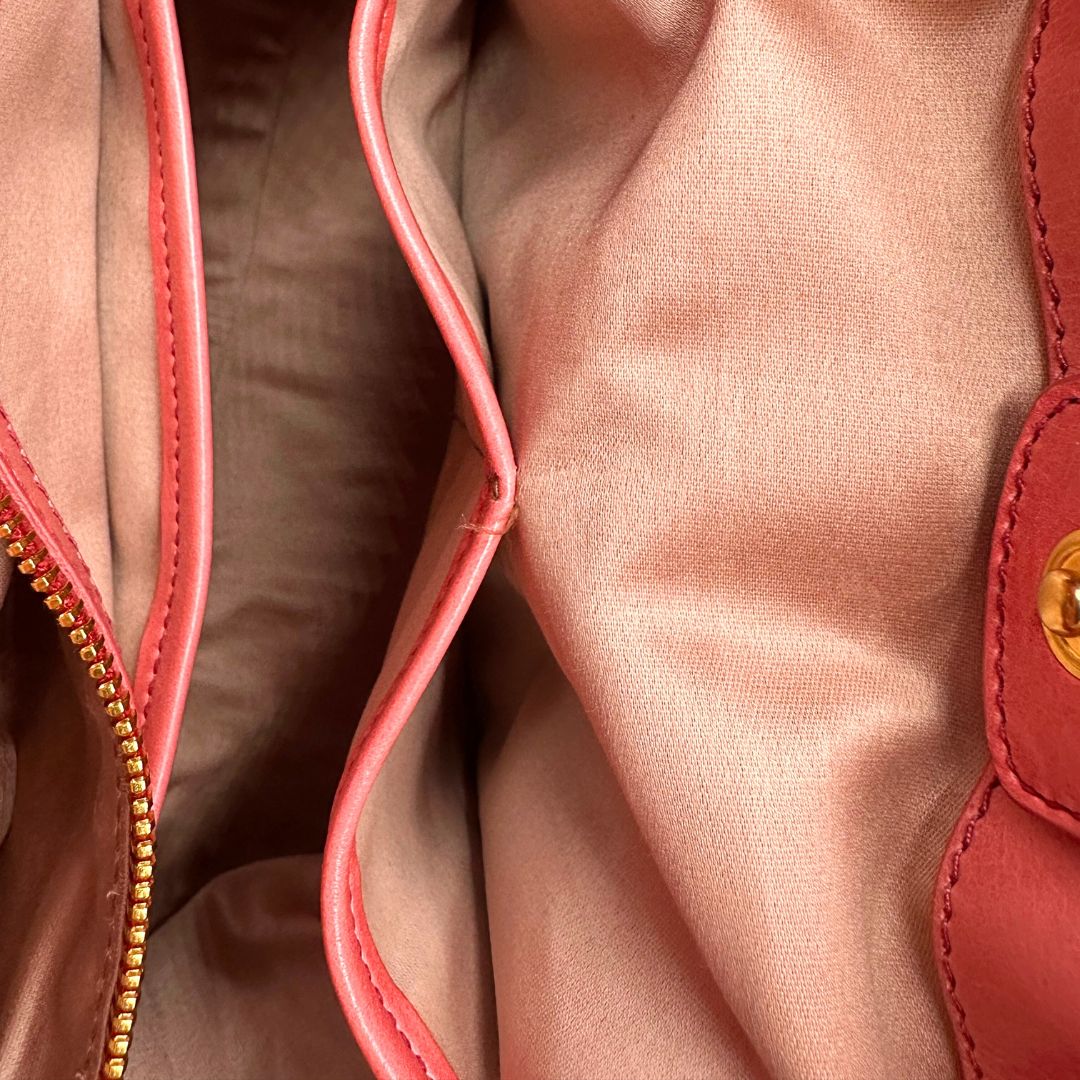 interno Borsa Miu Miu in pelle color rosa corallo con parti metalliche dorate; munita di doppi manici stondati e una tracolla amovibile. Completa di dustbag, di lusso, originale, ottime condizioni. 