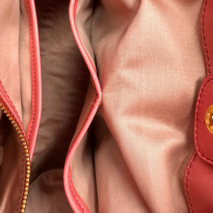 interno Borsa Miu Miu in pelle color rosa corallo con parti metalliche dorate; munita di doppi manici stondati e una tracolla amovibile. Completa di dustbag, di lusso, originale, ottime condizioni. 