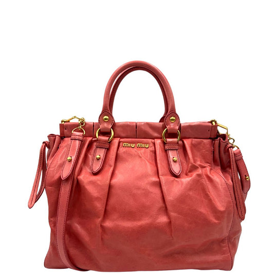 front Borsa Miu Miu in pelle color rosa corallo con parti metalliche dorate; munita di doppi manici stondati e una tracolla amovibile. Completa di dustbag, di lusso, originale, ottime condizioni. 