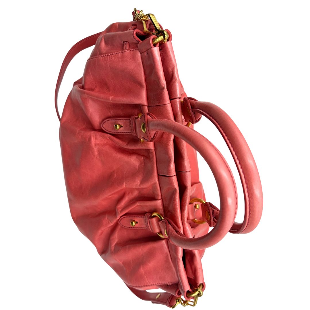 manici Borsa Miu Miu in pelle color rosa corallo con parti metalliche dorate; munita di doppi manici stondati e una tracolla amovibile. Completa di dustbag, di lusso, originale, ottime condizioni. 