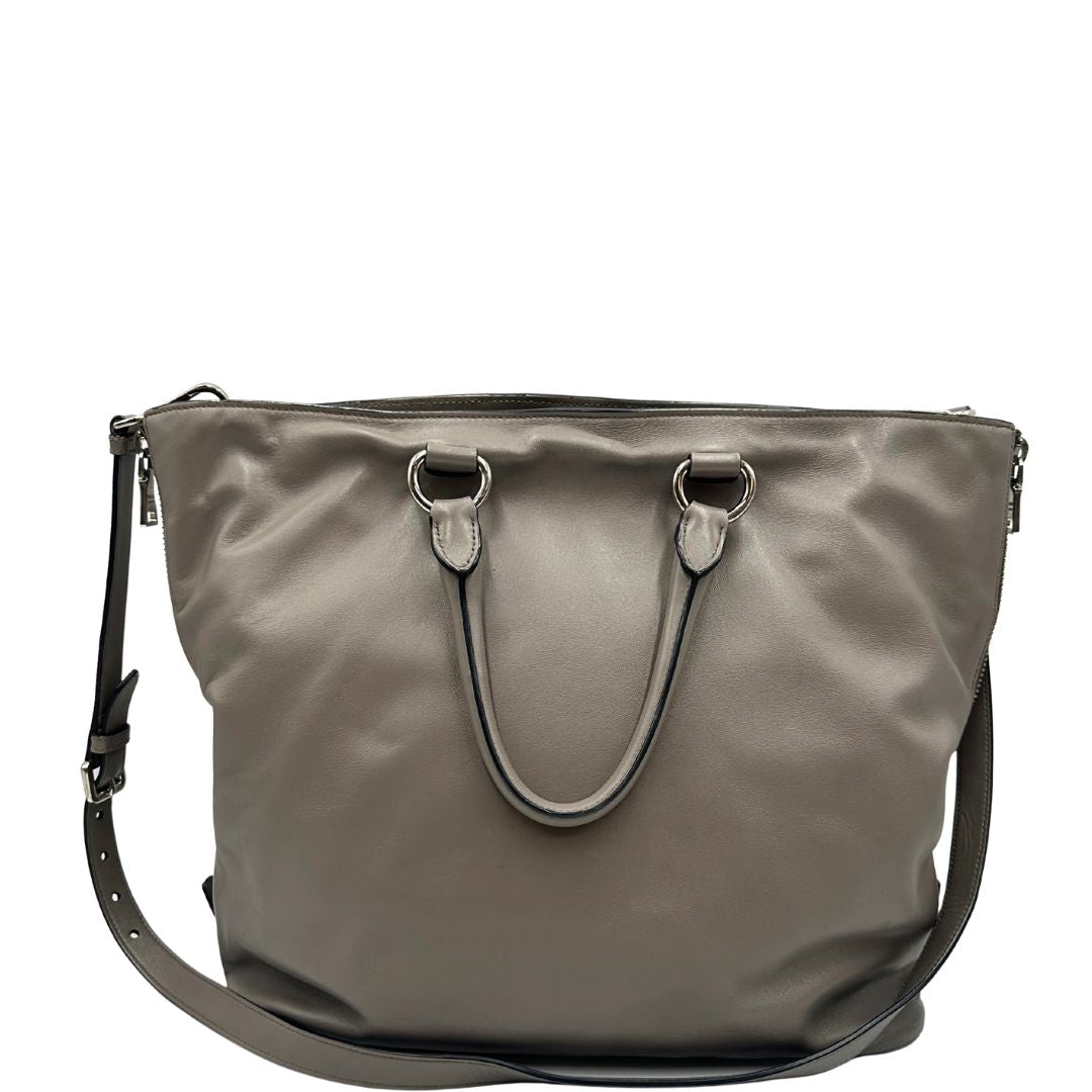 retro Borsa Prada in pelle grigia con parti metalliche argentate; impreziosita da zip laterali e accessorio porta address, munita di doppi manici stondati e una tracolla amovibile e regolabile. Completa di dustbag, di lusso, originale, ottime condizioni. 