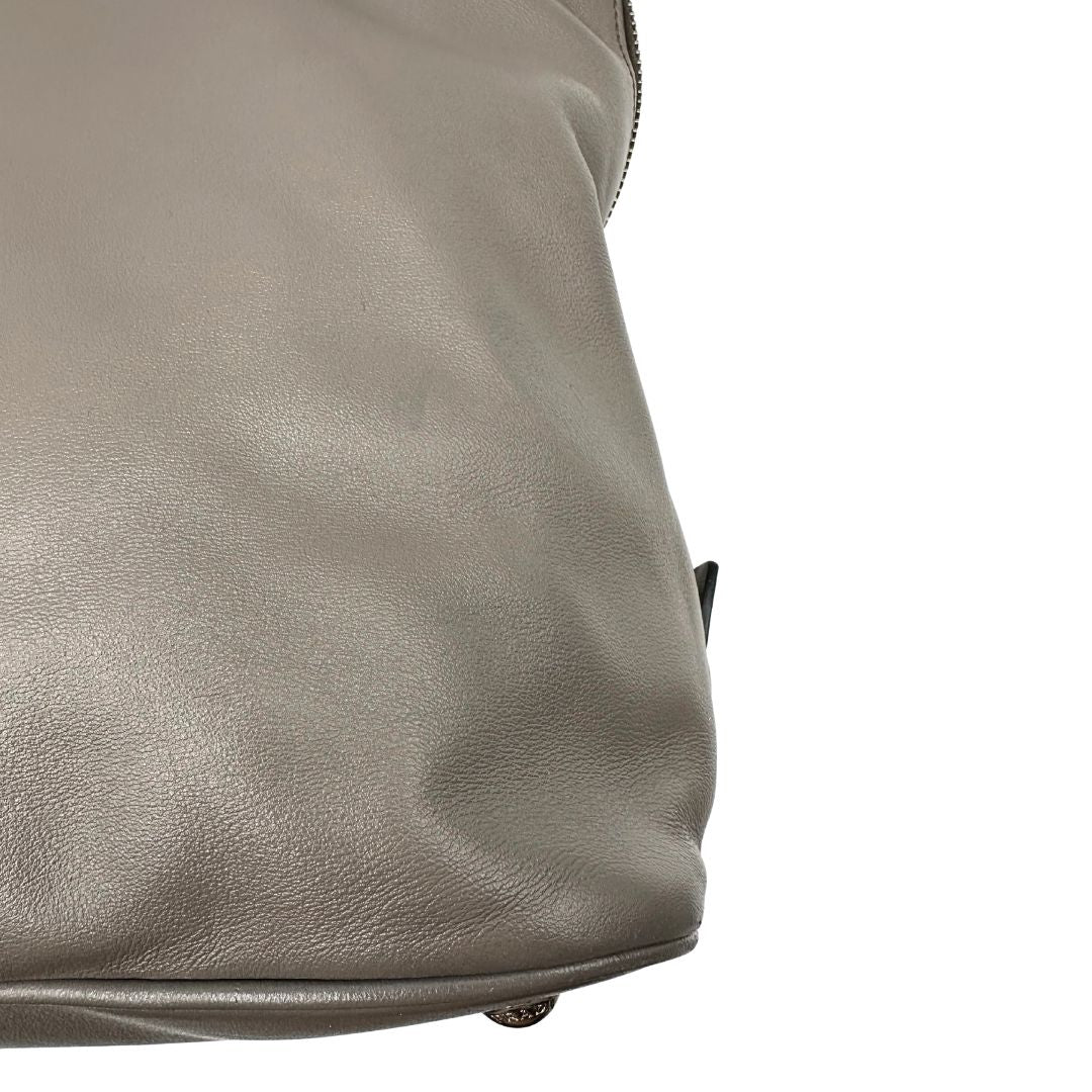 angolo Borsa Prada in pelle grigia con parti metalliche argentate; impreziosita da zip laterali e accessorio porta address, munita di doppi manici stondati e una tracolla amovibile e regolabile. Completa di dustbag, di lusso, originale, ottime condizioni.