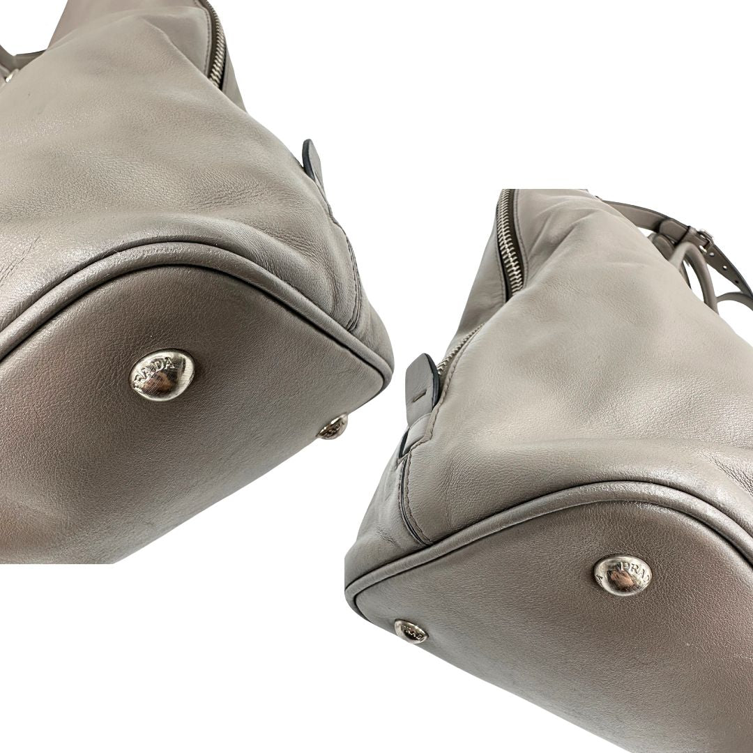 angoli Borsa Prada in pelle grigia con parti metalliche argentate; impreziosita da zip laterali e accessorio porta address, munita di doppi manici stondati e una tracolla amovibile e regolabile. Completa di dustbag, di lusso, originale, ottime condizioni. 