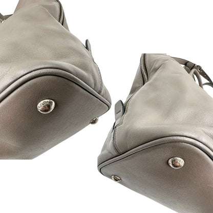 angoli Borsa Prada in pelle grigia con parti metalliche argentate; impreziosita da zip laterali e accessorio porta address, munita di doppi manici stondati e una tracolla amovibile e regolabile. Completa di dustbag, di lusso, originale, ottime condizioni. 