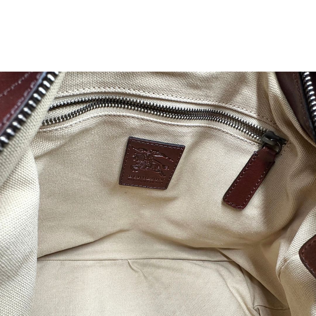 Tasca interna di una Borsa Tote Burberry in tessuto bianco trama tartan nera e rossa, finiture in pelle marrone e parti metalliche effetto renio, munita di doppie manici e una tracolla regolabile, amovibile con spallaccio. Indossabile a spalla. Originale, usata, di lusso, in ottime condizioni.