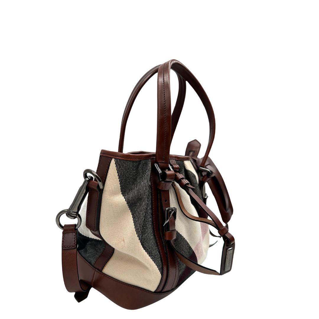 Lato destro di una Borsa Tote Burberry in tessuto bianco trama tartan nera e rossa, finiture in pelle marrone e parti metalliche effetto renio, munita di doppie manici e una tracolla regolabile, amovibile con spallaccio. Indossabile a spalla. Originale, usata, di lusso, in ottime condizioni.