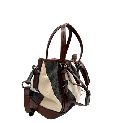 Lato destro di una Borsa Tote Burberry in tessuto bianco trama tartan nera e rossa, finiture in pelle marrone e parti metalliche effetto renio, munita di doppie manici e una tracolla regolabile, amovibile con spallaccio. Indossabile a spalla. Originale, usata, di lusso, in ottime condizioni.