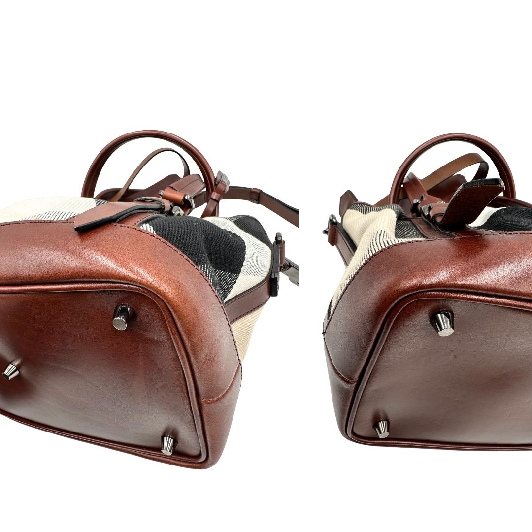 Angoli di una Borsa Tote Burberry in tessuto bianco trama tartan nera e rossa, finiture in pelle marrone e parti metalliche effetto renio, munita di doppie manici e una tracolla regolabile, amovibile con spallaccio. Indossabile a spalla. Originale, usata, di lusso, in ottime condizioni.