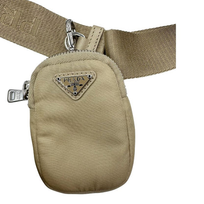 Borsa Prada in Re-Nylon beige con finiture in pelle saffiano tono su tono, munita di un manico in catena e una tracolla in tessuto regolabile e amovibile, impreziosita da pouch rimovibile. Rifinita con parti metalliche argentate e iconico triangolo logato sul front. Indossabile a spalla oppure a tracolla. Originale, usata, di lusso, in ottime condizioni