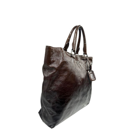 lato Borsa Prada in pelle lucida color cioccolato con parti metalliche argentate; munita di un accessorio porta address e doppi manici. Completa di dustbag, di lusso, originale, ottime condizioni. 