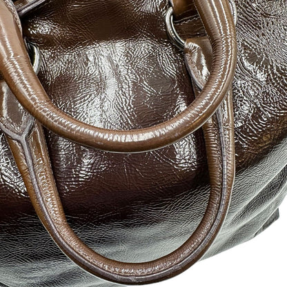 manici Borsa Prada in pelle lucida color cioccolato con parti metalliche argentate; munita di un accessorio porta address e doppi manici. Completa di dustbag, di lusso, originale, ottime condizioni. 