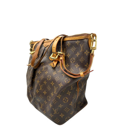 Lato sinistro di una Borsa Palermo GM Louis Vuitton in canvas marrone monogram con finiture in vacchetta naturale e parti metalliche dorate. Originale, usato, di lusso, in ottime condizioni.