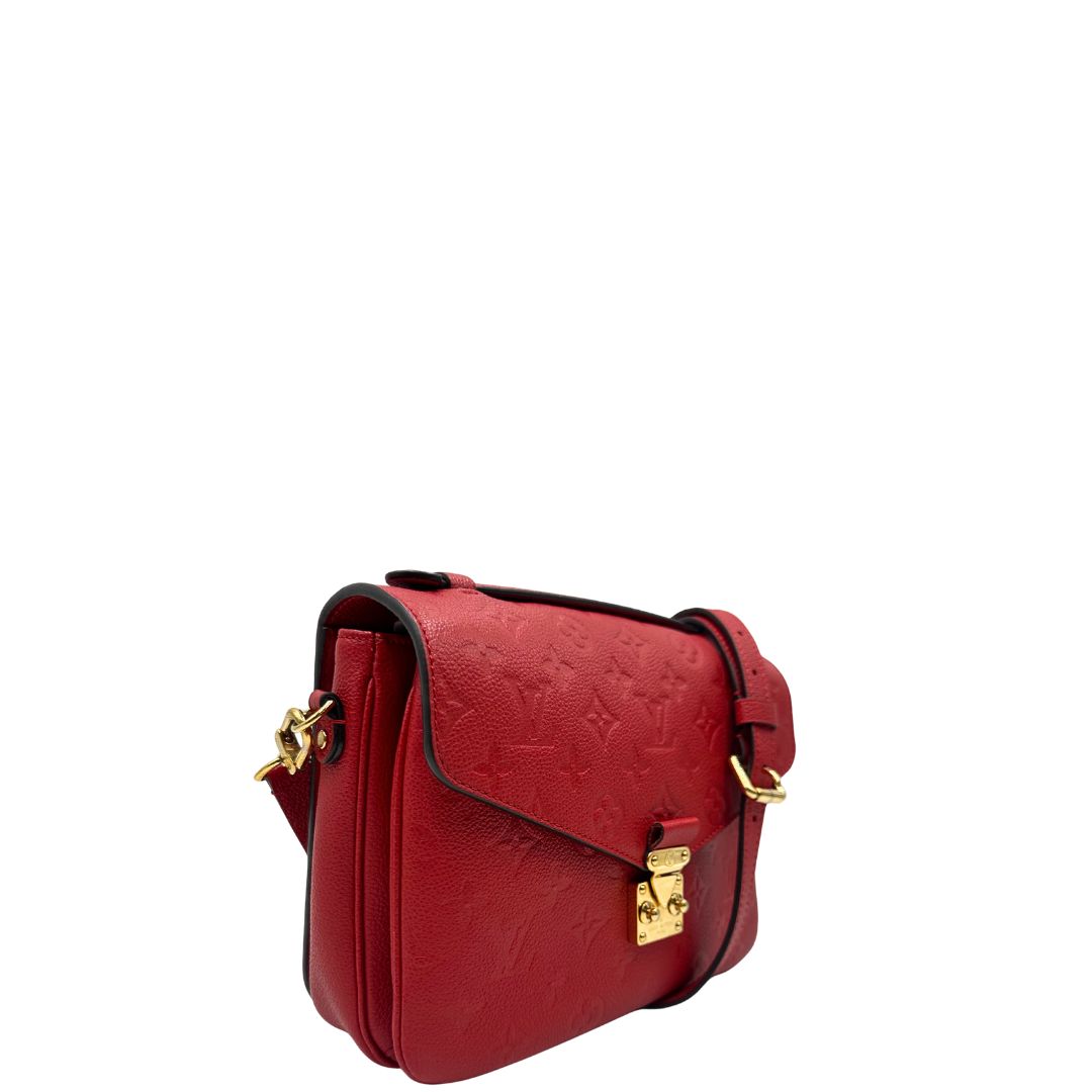 lato Borsa Louis Vuitton Métis in pelle martellata rossa con trama monogram e parti metalliche dorate. Munita di un manico singolo e una tracolla regolabile e amovibile. Completa di corredo, di lusso, originale, ottime condizioni, usata. 