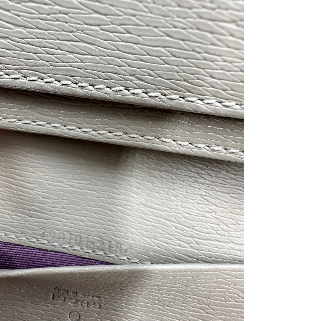 Codice di un Portafoglio Gucci in pelle Grigia con parti metalliche dorate. Completo di scatola e dustbag. Originale, usato, di lusso in condizioni eccellenti.